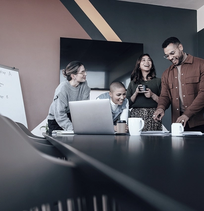 Team of professionals collaborating around a table with a laptop.